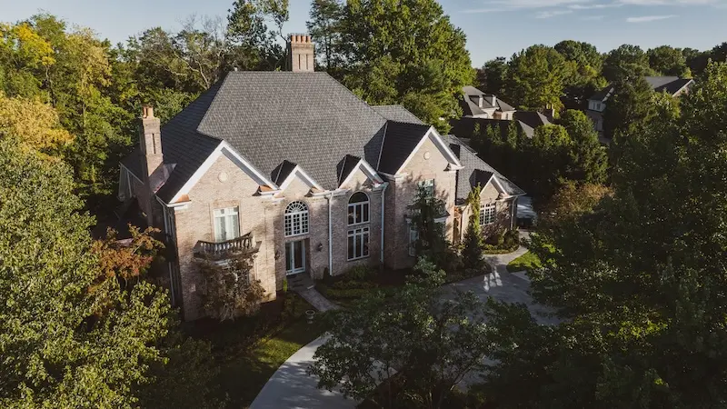 Aerial drone view of luxury brick estate with completed roof repair by Cardinal Contractors serving Kansas City and St. Louis Missouri