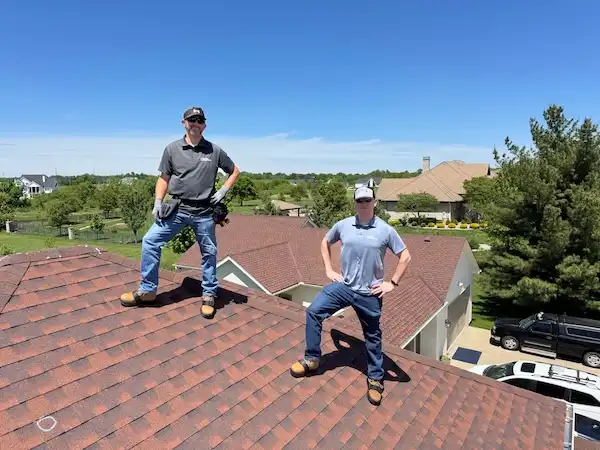 Cardinal Contractors roofing crew standing on completed residential roof replacement in Lenexa KS