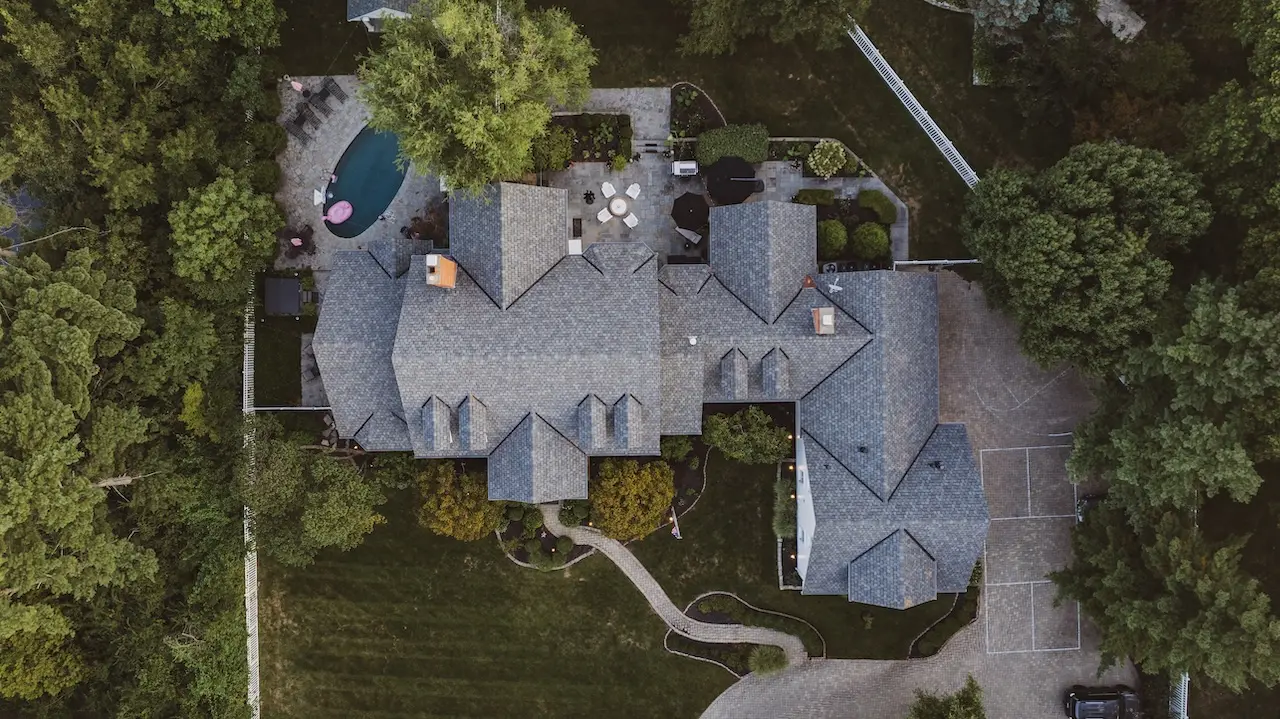 Overhead drone view of massive luxury estate with complex multi-pitch roof replacement completed by Cardinal Contractors serving Kansas City and St. Louis Missouri