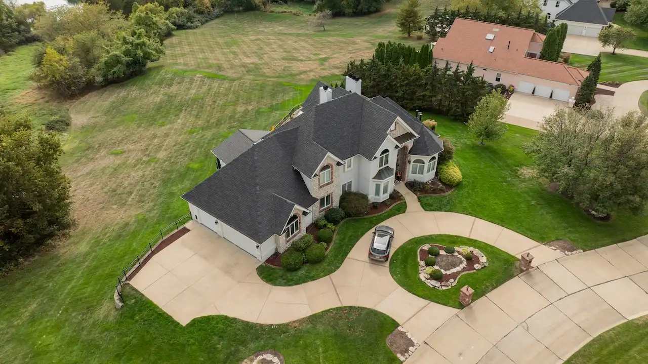 Aerial drone view of luxury estate with completed roof replacement by Cardinal Contractors in Shawnee KS