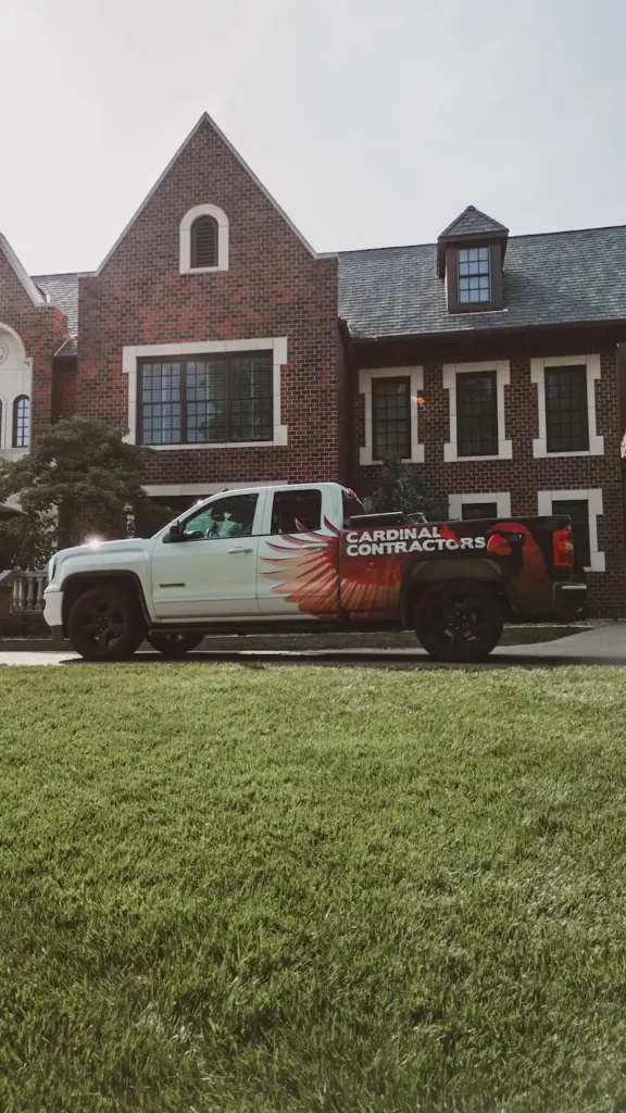 Cardinal Contractors branded truck parked at Tudor brick estate for insurance claim roofing inspection in St. Louis MO